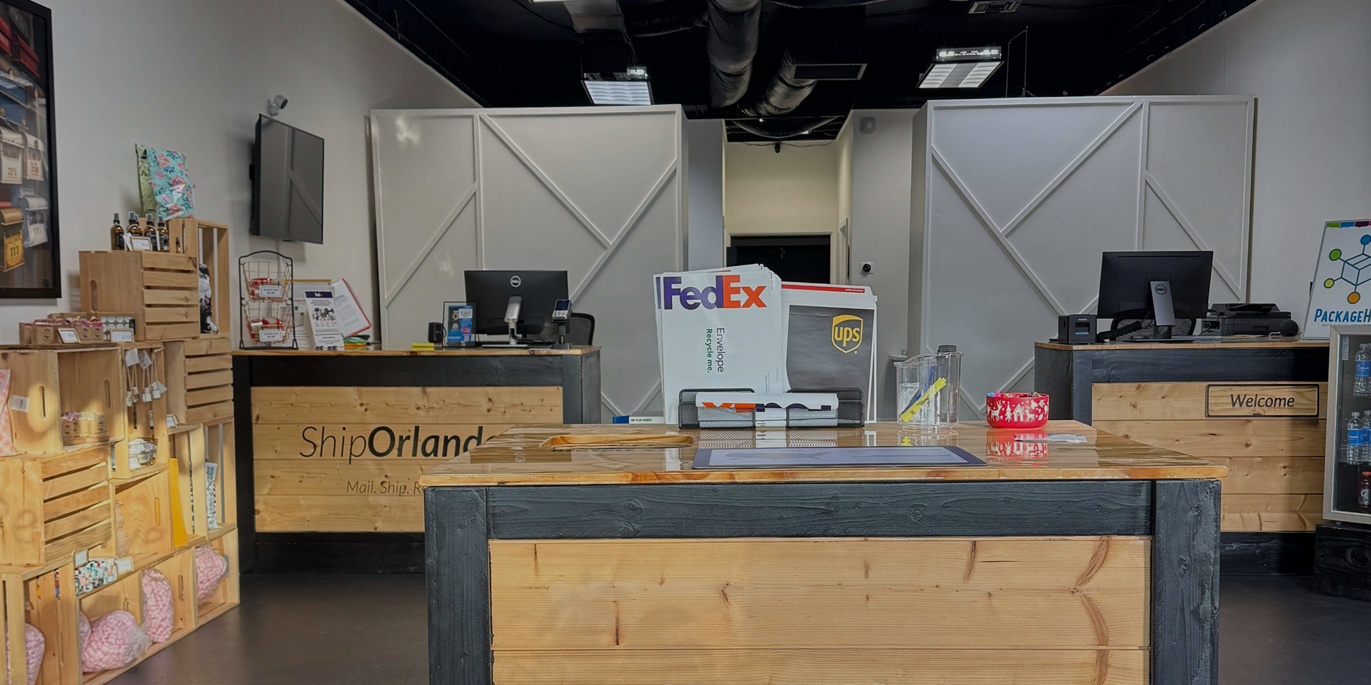 Interior of ShipOrlando shipping store with wooden service counter, FedEx and UPS displays, and shelving with packages