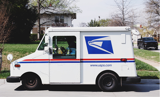 White USPS mail delivery truck parked on residential street