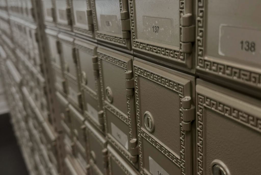 Row of numbered post office boxes with ornate brass doors and keyholes